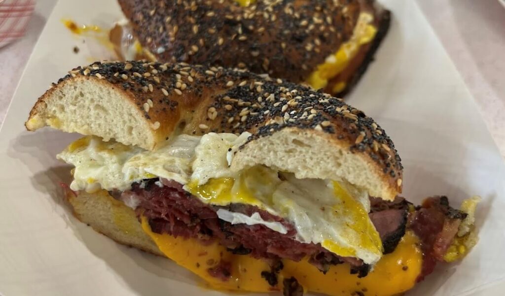 The ultimate Bagel Egg Sandwich at Meshugana Deli, Sarasota's breakfast of champions, featuring high-quality ingredients and home-made meats.